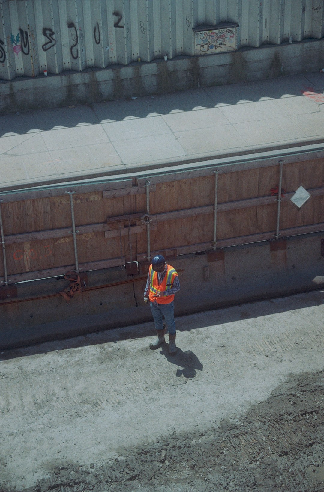 construction-worker-in-safety-vest-stands-on-dirt-6nlytjiya24
