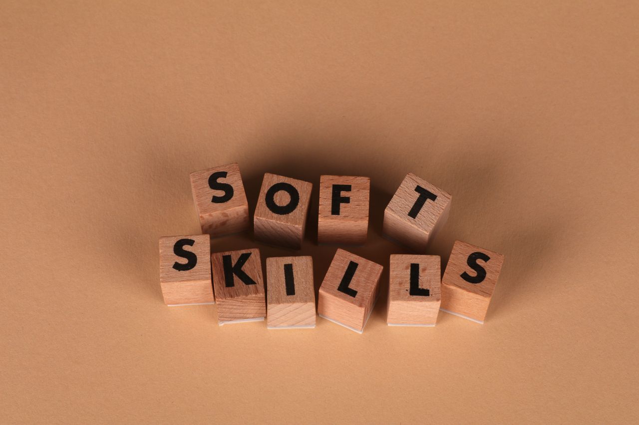Wooden letter blocks spell out Soft Skills, highlighting business and personal development concepts.